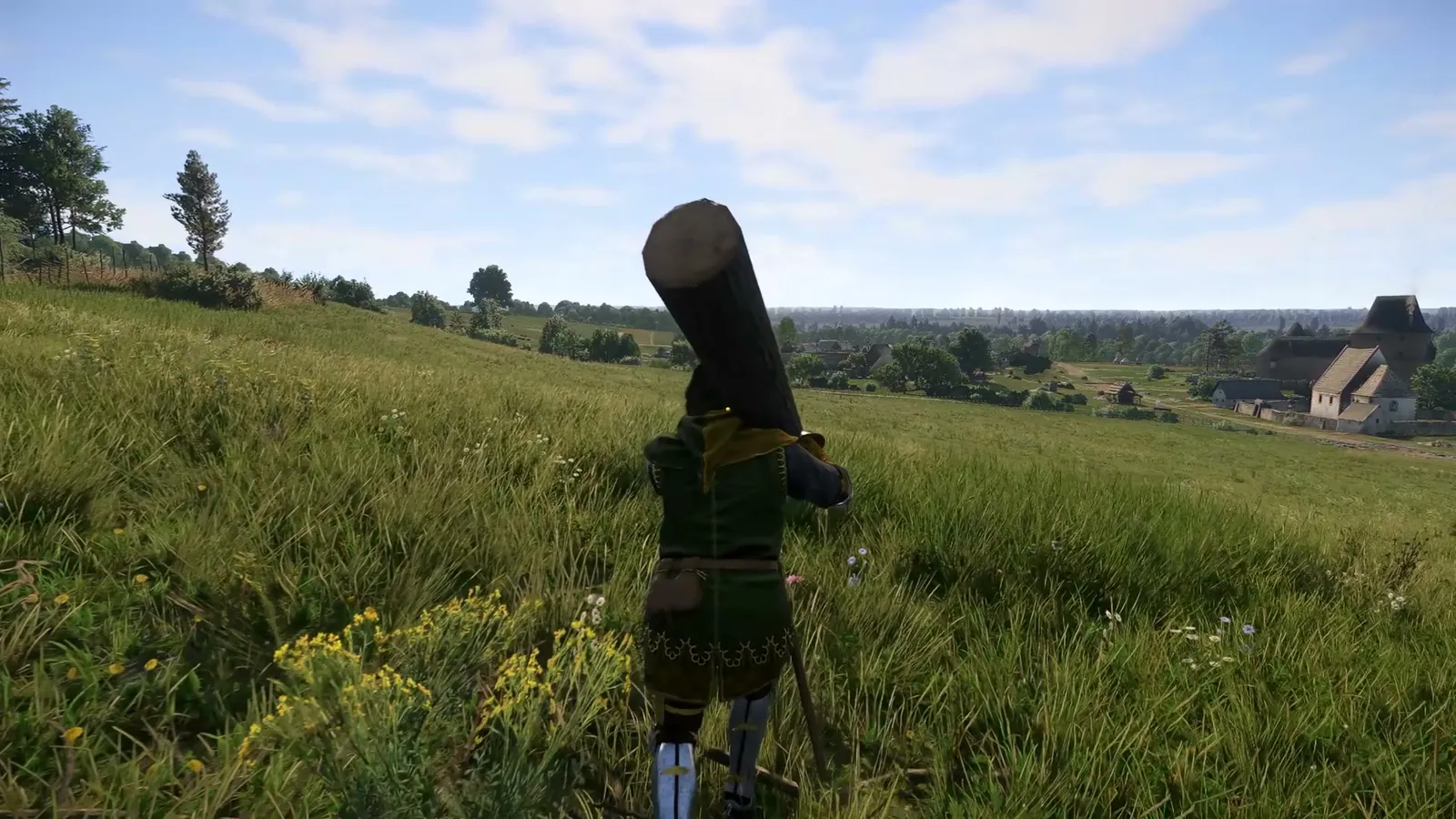 Captura del juego: un personaje con un tronco al hombro por el prado, con Sotodal al fondo.